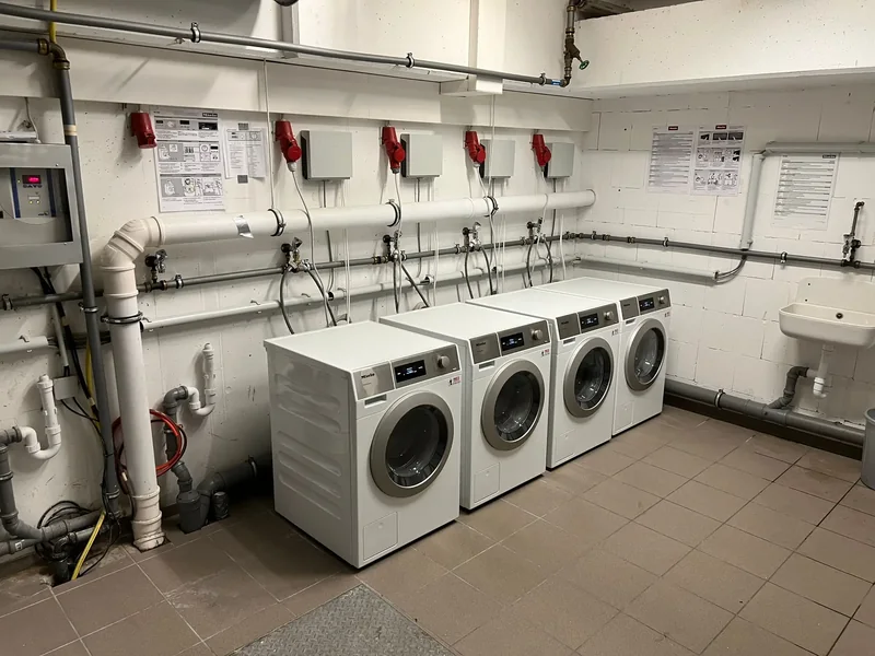 Gemeinschaftswaschraum mit mehreren Waschmaschinen und Kassiersystemen